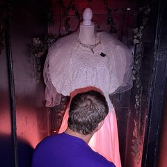 A player searching beneath the ghost bride's wedding dress in the Ghost Bride escape room